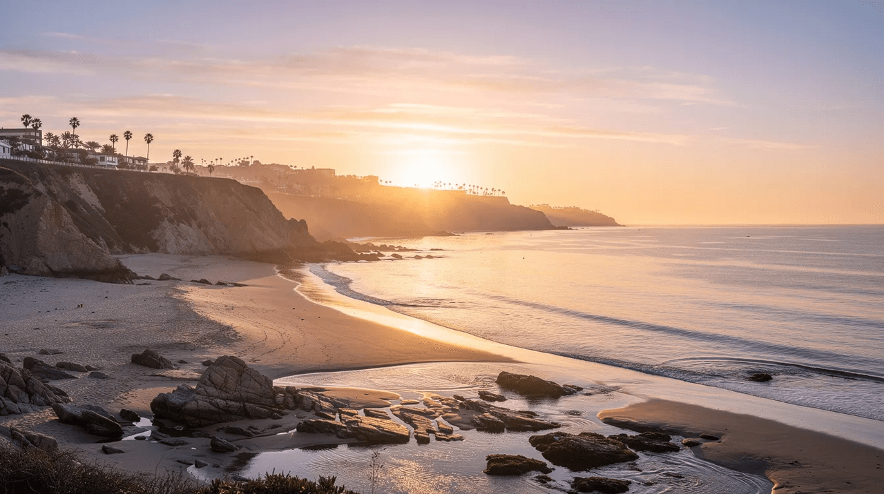 The image depicts a serene sunrise over the Southern California coastline, with soft golden light reflecting on the calm ocean water, symbolizing healing and recovery in the context of trauma-informed care. This tranquil scene evokes a sense of safety and well-being, essential for mental health and trauma survivors.